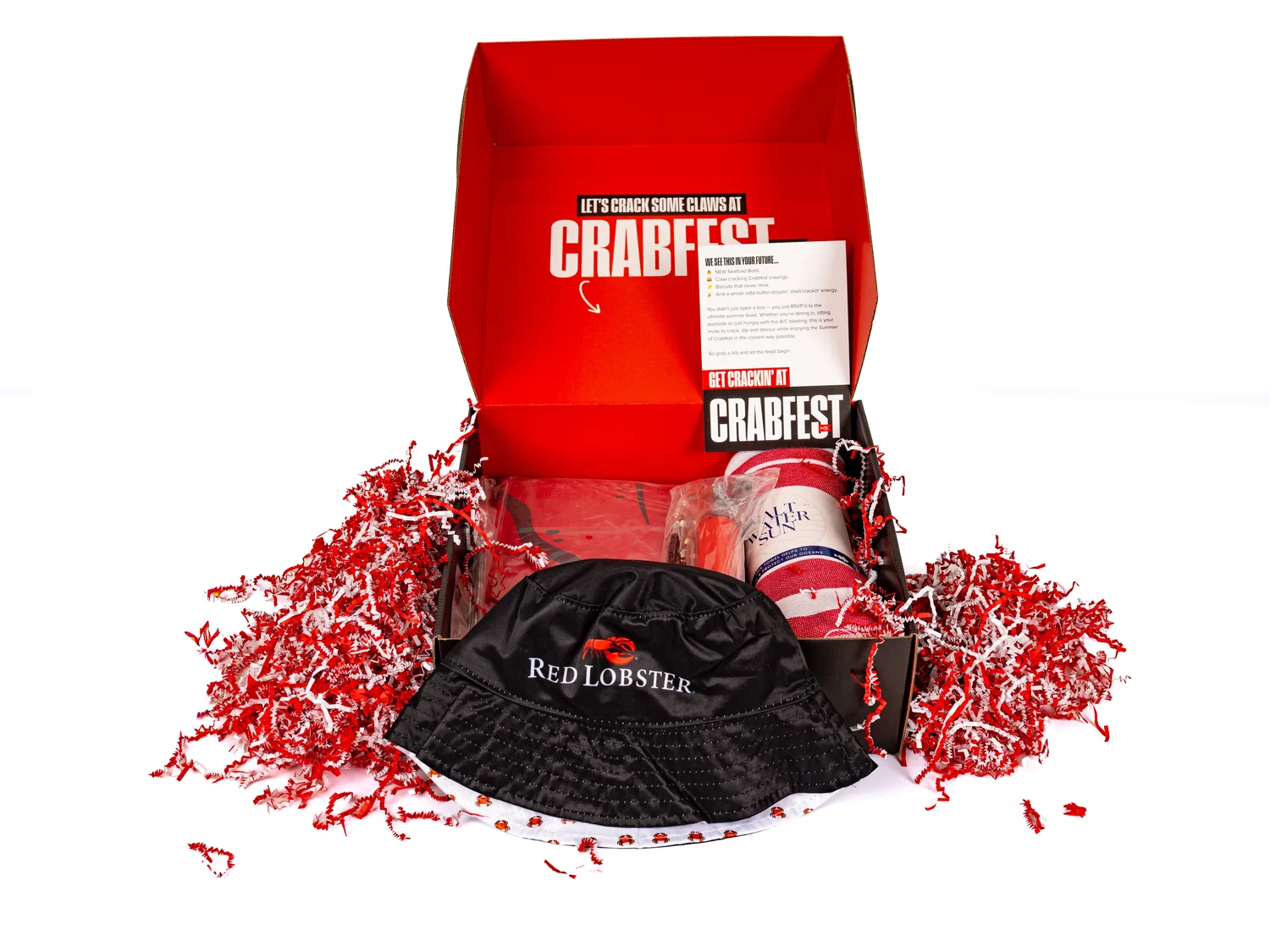 Branded promotional kit — open box with bucket hat, towel, and event collateral